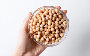 Hand holding a small glass bowl filled with chickpeas