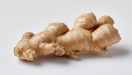 A whole ginger root, light brown in color, lies on a plain white background.  The root has multiple knobby sections, and its surface is somewhat rough and textured