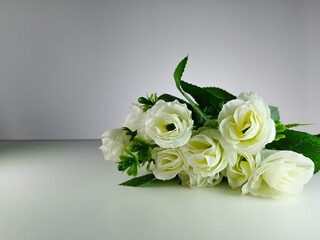 Picture of artificial white rose with white background. This photo can be used for wedding organizer advertising or other advertising that related to marriage