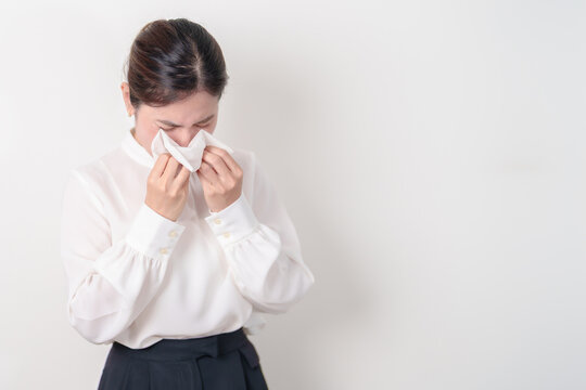 business woman blowing her nose with tissue for concepts of Common Cold, Influenza, Flu, Hay, Fever, Covid 19, Respiratory Infection, Sinusitis, Allergic Rhinitis, Allergy, Medical and health care