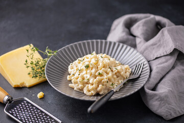 American simple dish mac and cheese. Pasta with cheese and cream sauce in a plate on the table.