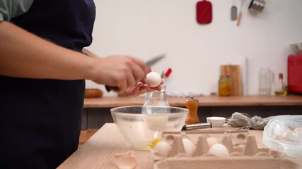 Woman chef cracks fresh eggs in the glass bowl cooking breakfast in the kitchen. - Powered by Adobe