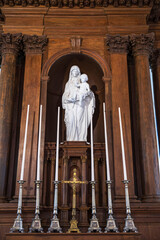 Statue of the Virgin Mary in an old church against a carved wooden wall