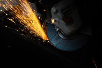 Man processes metal with an angle grinder.