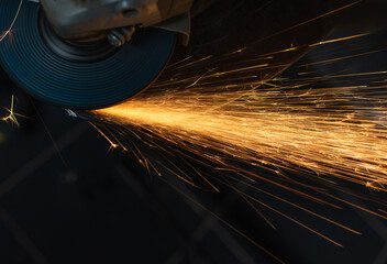Man processes metal with an angle grinder.