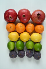 Vibrant rainbow of fresh figs, citrus fruits, and pomegranates. Perfect for cookbook recipes, culinary magazines, and healthy eating illustrations.