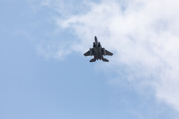 A powerful American twin-engine fighter jet flying in the sky during an air show event, demonstrating military aviation speed, agility, and maneuverability against the clouds, captured in Oregon, USA