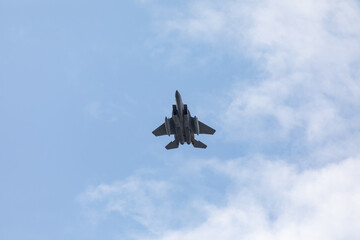 A powerful American twin-engine fighter jet flying in the sky during an air show event, demonstrating military aviation speed, agility, and maneuverability against the clouds, captured in Oregon, USA