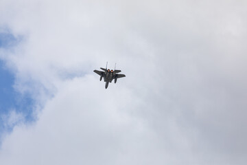 A powerful American twin-engine fighter jet flying in the sky during an air show event, demonstrating military aviation speed, agility, and maneuverability against the clouds, captured in Oregon, USA