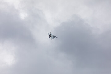 A powerful American twin-engine fighter jet flying in the sky during an air show event, demonstrating military aviation speed, agility, and maneuverability against the clouds, captured in Oregon, USA