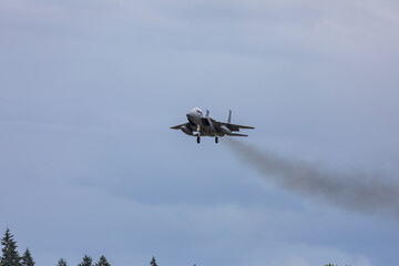 A powerful American twin-engine fighter jet flying in the sky during an air show event, demonstrating military aviation speed, agility, and maneuverability against the clouds, captured in Oregon, USA
