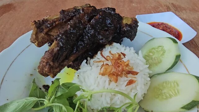 rice with chicken Nasi bebek madura,Fried duck or Roasted duck with black sauce topping served with rice,fresh vegetables and sambal or chili sauce,traditional dish from Maduranese in Madura island Ea