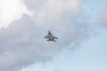 A powerful American twin-engine fighter jet flying in the sky during an air show event, demonstrating military aviation speed, agility, and maneuverability against the clouds, captured in Oregon, USA