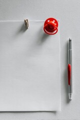 Blank white sheet of paper, red pacifier, pen