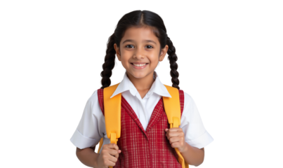 Smiling schoolgirl in uniform with a backpack, ready for her first day of school