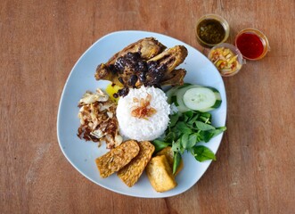 chicken with riceNasi bebek set menu is deep fried duck served with rice,fried tempeh,fried tofu,fried cabbage,fresh vegetables and sambal or chili sauce and mango sambal Indonesian traditional food