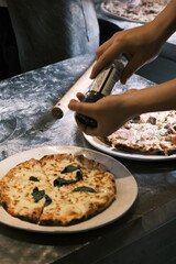 A chef is making traditional Italian pizza by hand