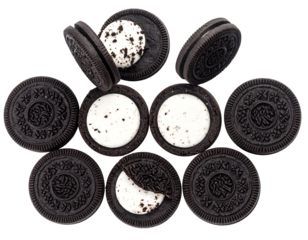 Top-down view of several chocolate sandwich cookies, some sliced open, revealing white cream filling dotted with tiny bits