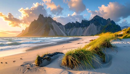 Sunset over a sandy beach with dramatic mountains
