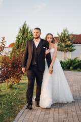 Gentle and happy bride and groom at sunset walking in the park. Romantic.