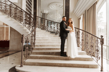 The bride and groom are on a beautiful staircase.
