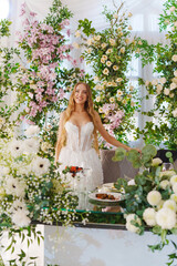 A bride at the table of the newlyweds, decorated with flowers