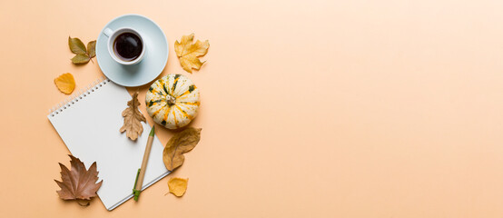 Autumn composition: fallen leaves and notebook mock up on colored background. Top view. Flat lay with copy space