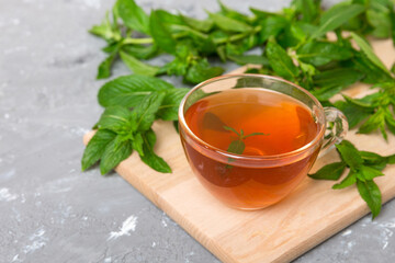 Cup of mint tea on table background. Green tea with fresh mint top view with copy space