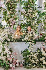 The bride and groom at the newlyweds' table, decorated with many flowers. 