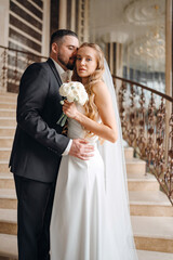 The bride and groom are on a beautiful staircase.