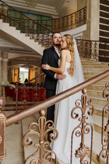 The bride and groom are on a beautiful staircase.
