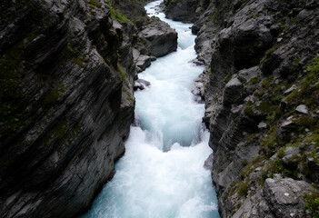 Obraz premium River Rapids Carving Through Rocky Gorge