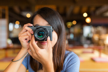 Female photographer aiming digital camera at her face