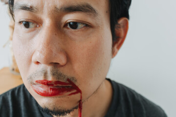 Portrait of Thai man with uneven red lipstick showing raw emotional intensity and sadness