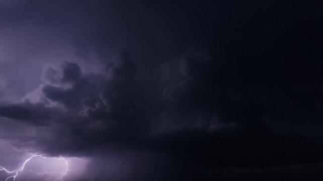 As the storm rages on, dark thunderclouds dance with electric flashes, turning the night sky into a breathtaking spectacle of nature's fury.
