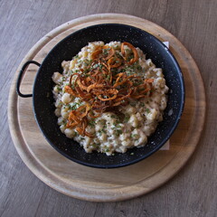 Noodles Spaetzle with cheese and roasted onion in Austria, Europe 
