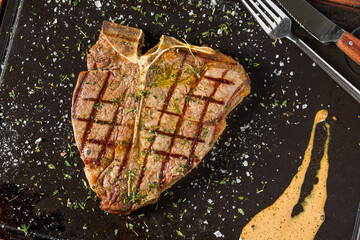 Classic T-Bone steak grilled and served on hot stone board