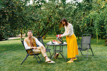 Family Drinking Tea Together In Sunny Garden