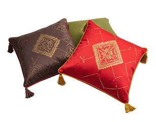 Three decorative pillows, patterned and tasseled, in shades of red, brown, and olive green