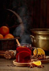 Mulled wine with ingredients on an old wooden table.