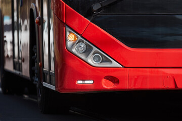 Red bus for public transportation on city streets.