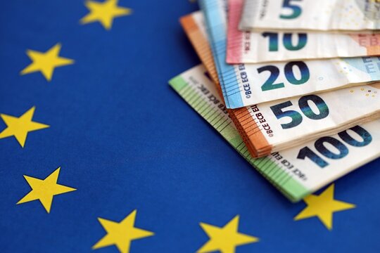 European eur currency money bills on Euro union blue flag close up