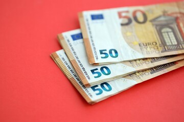 Big amount of european euro currency money notes on red color table close up
