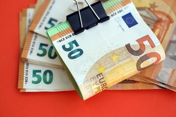 Big amount of european euro currency money notes on red color table close up