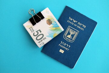 Israel New Shekels banknotes and passport on blue background. The current Israel money bills