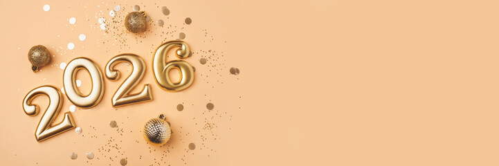 Golden 2026 on a peach color background with confetti and bokeh lights. Happy New Year 2026 is coming concept. Top view.