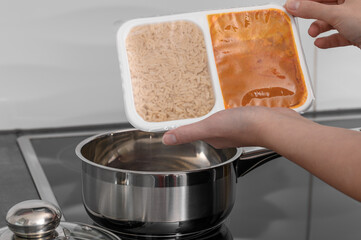 Dinner ready to be heated in a tightly closed plastic container, with rice in one compartment and chicken in korma sauce in the other.