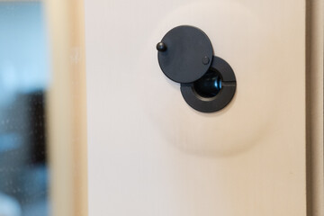 Door peephole on apartment entrance door panel. concept for safety and observation.