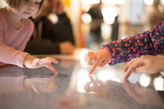 Girl uses touchscreen device for educational purposes, engaging with digital learning materials. Modern technology supports early childhood development through interactive and intuitive tools. - Powered by Adobe