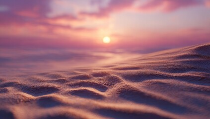 Soft, pink-hued sand dunes ripple gently under a vibrant sunset; hazy horizon and sun partially obscured by clouds